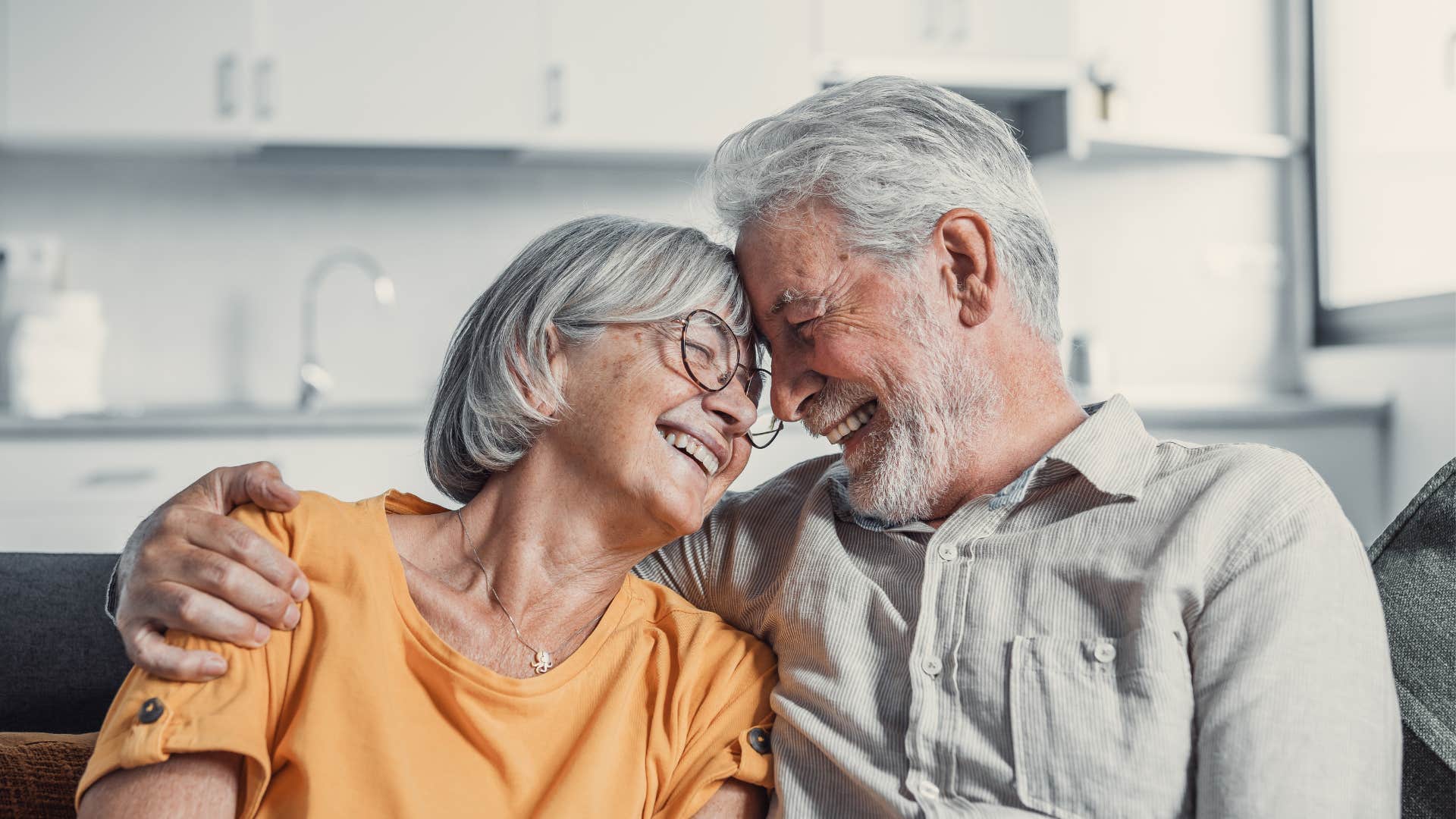 Older couple smiling and hugging each other.