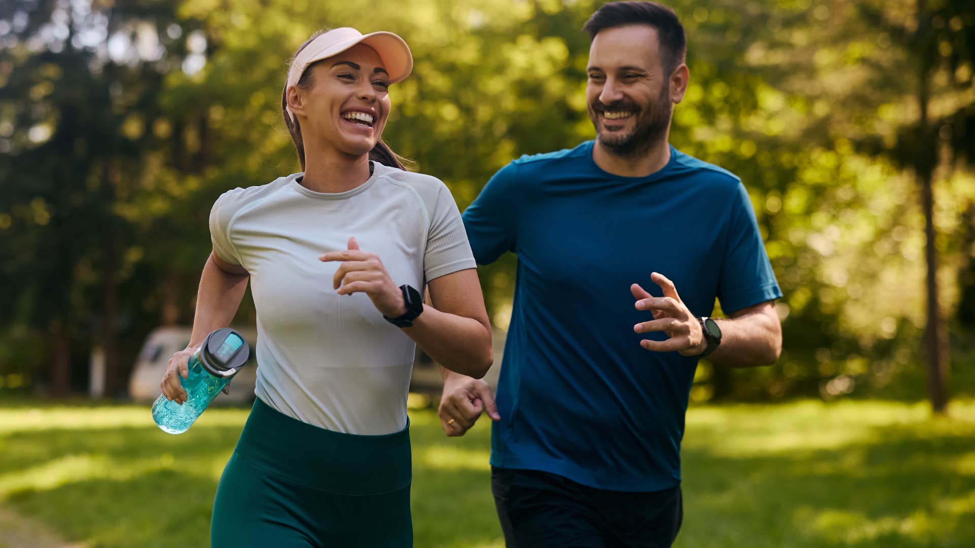 Couple smiling and running together outside.