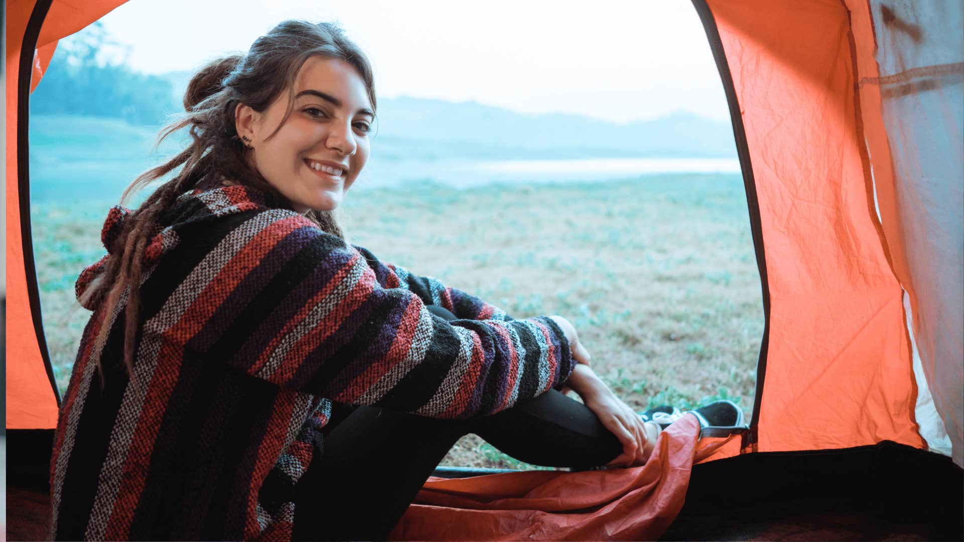 smiling woman in tent in a field