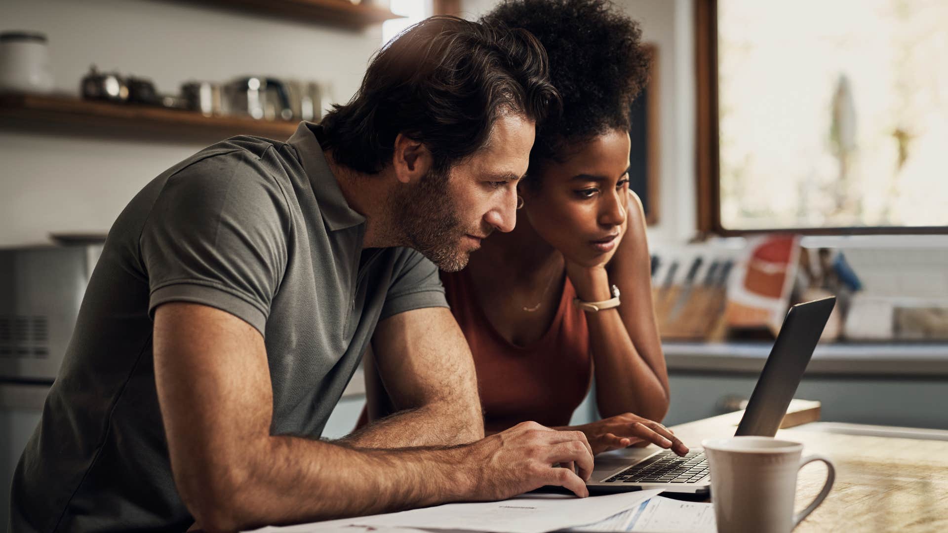 Couple smiling and doing bills together.