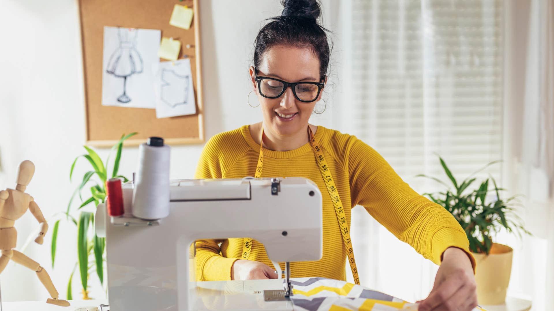 Woman smiling while using her sewing machine.