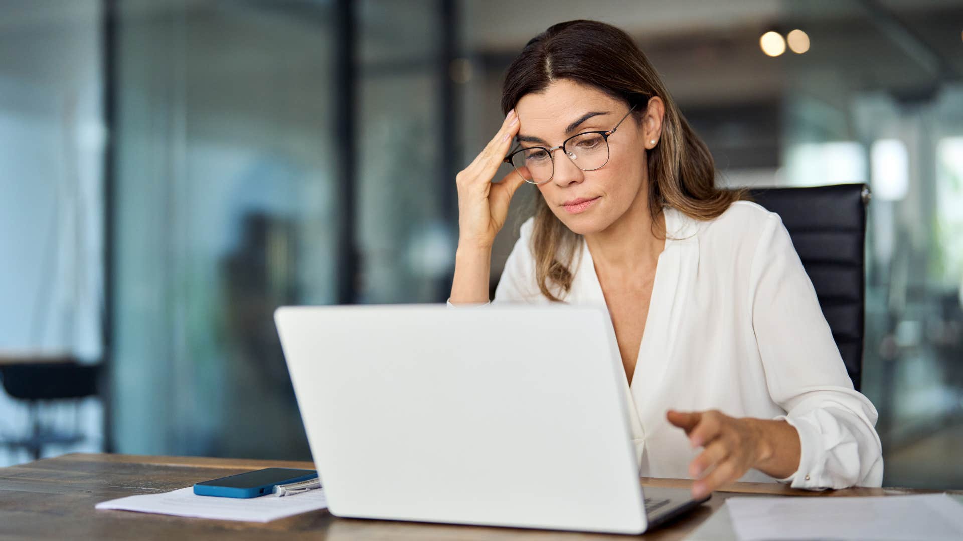 Tired woman working on her laptop in an office