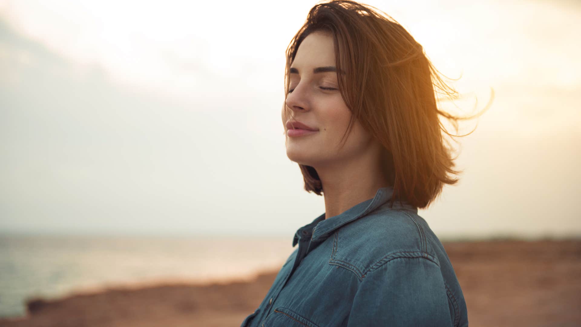 Woman closing her eyes and resting outside in nature