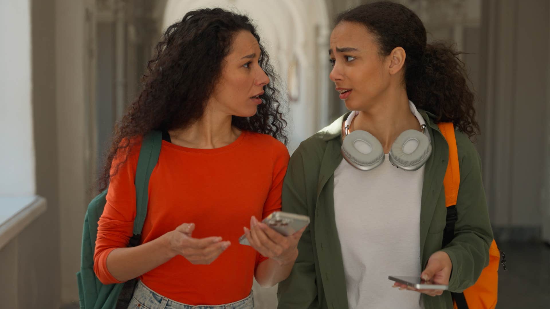 Two friends talking to each other and walking