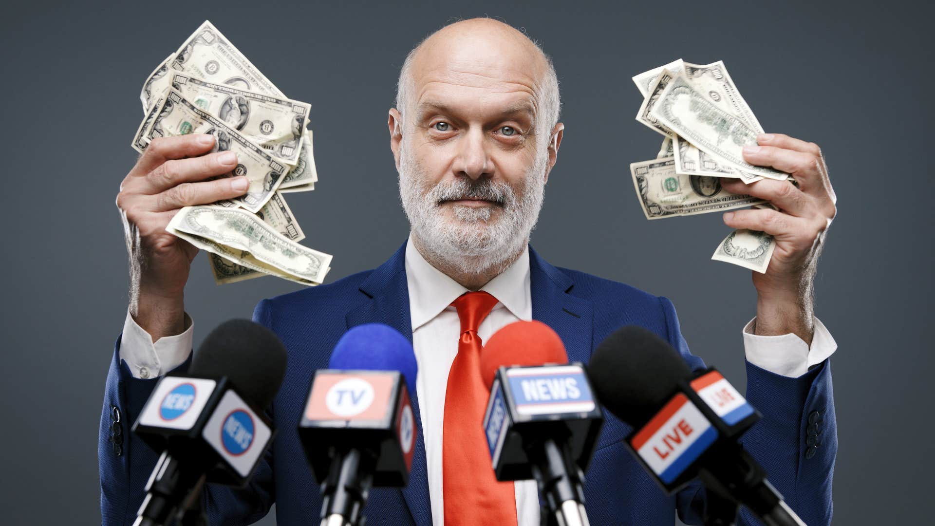 Politician holding up money in front of microphones