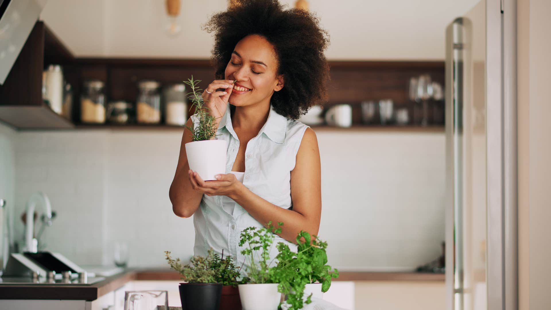 Woman smiling and smelling herbs from her garden