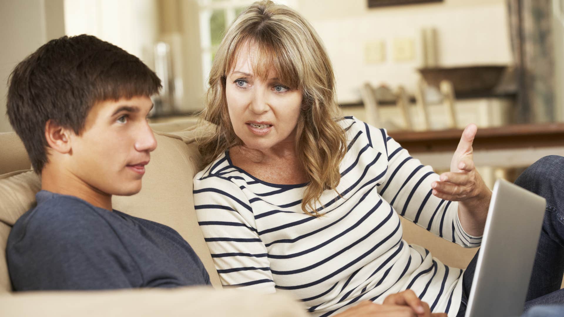 Woman arguing with her distracted teenage son.