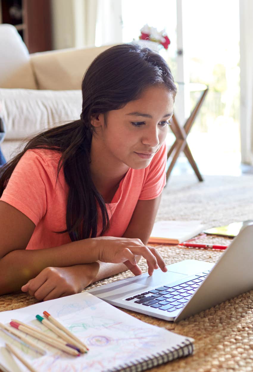 tween girl using AI to do homework on laptop