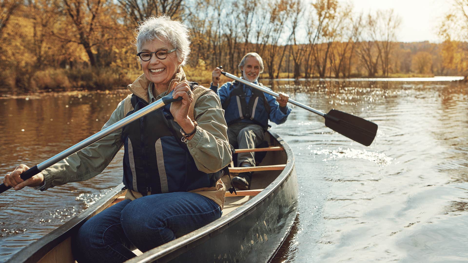 Older couple row canoe