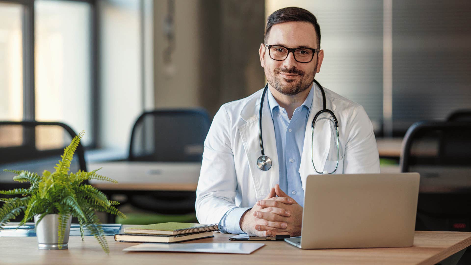 doctor sitting down and smiling at camera