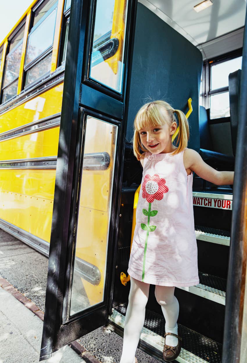 little girl getting off the school bus