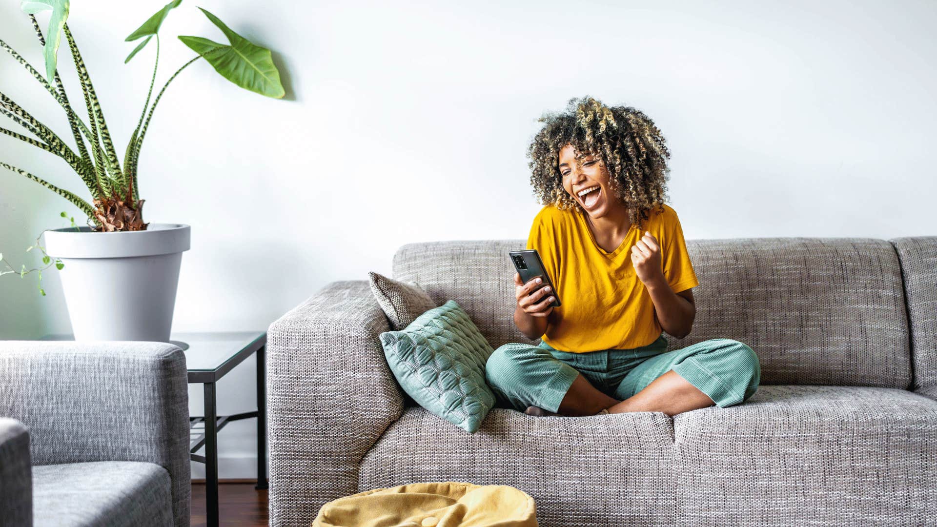 excited woman sitting on couch