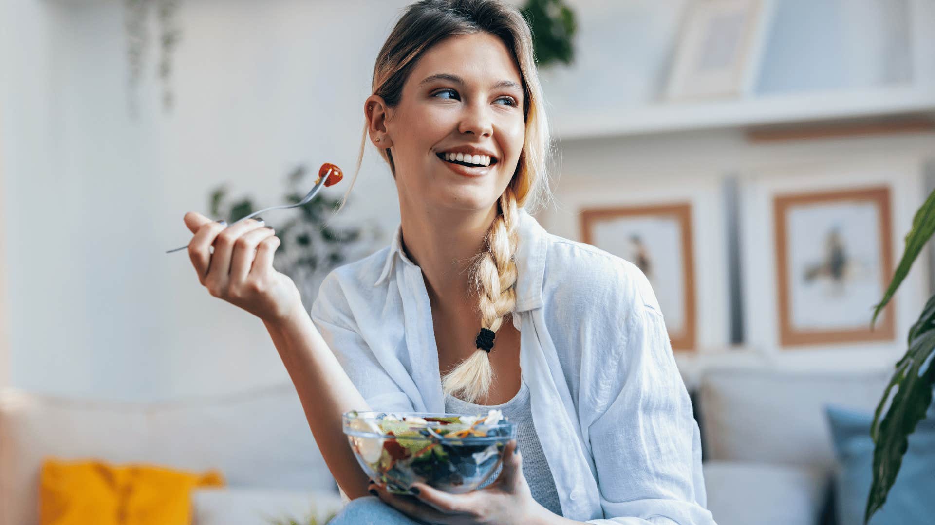 woman smiling and eating a salad