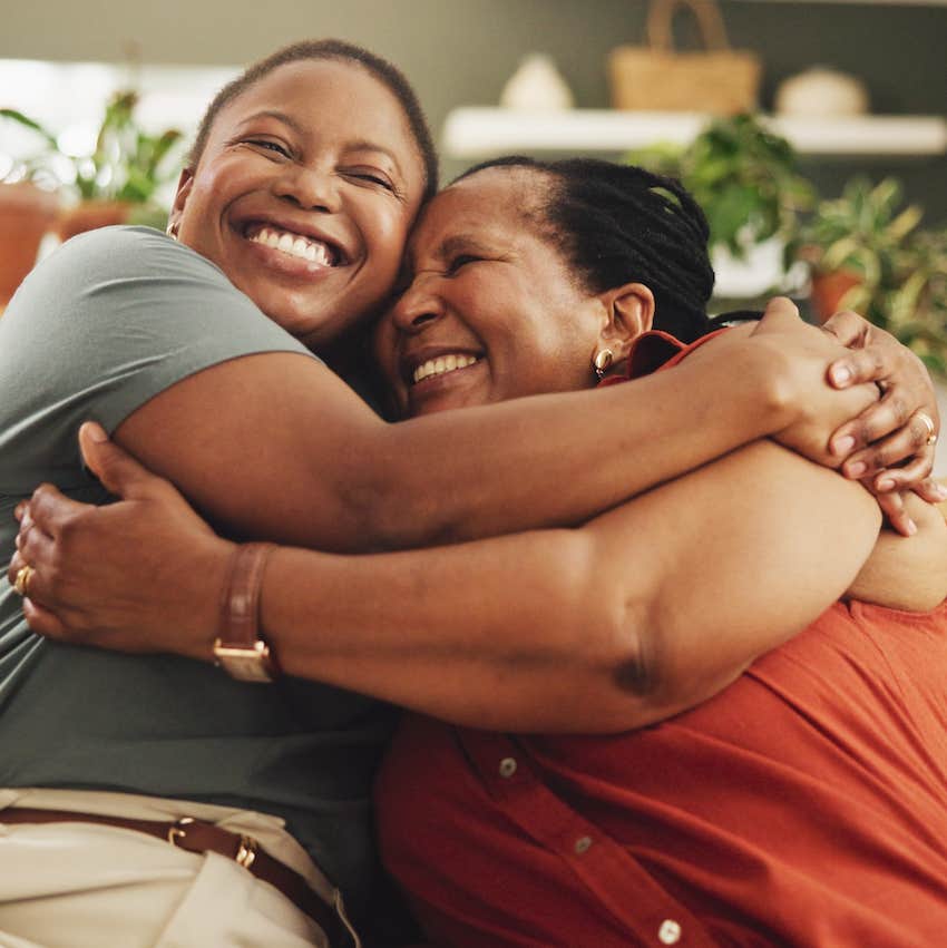 two people hugging on couch with happiness