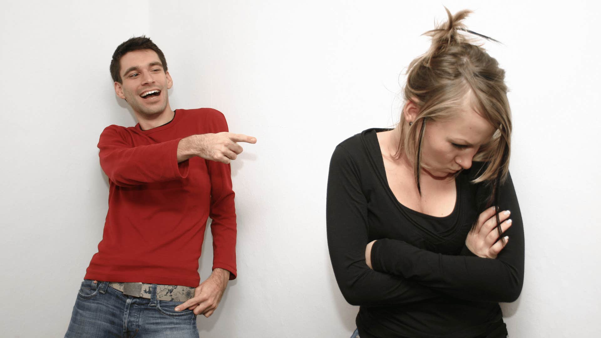 man pointing and laughing at woman