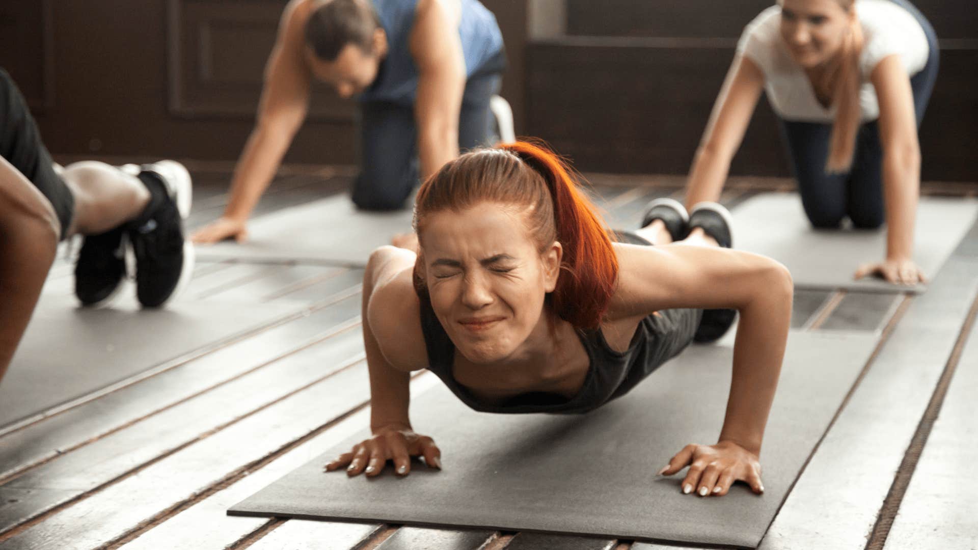 woman struggling to plank in class