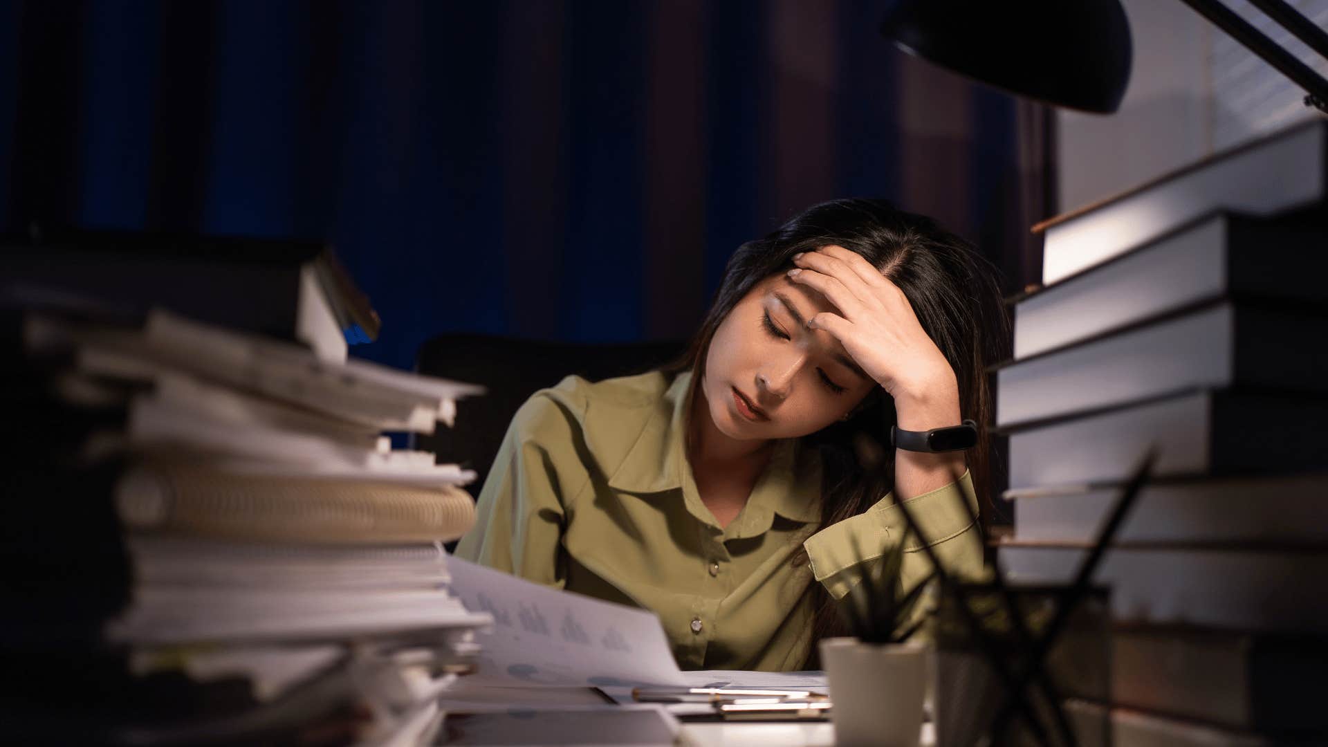 stressed woman with stacks of books