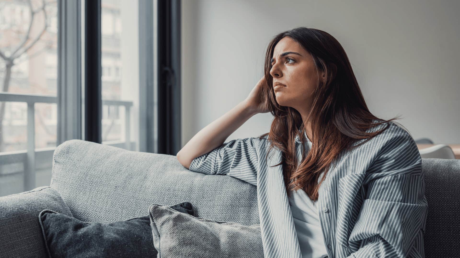 alone woman looking out window