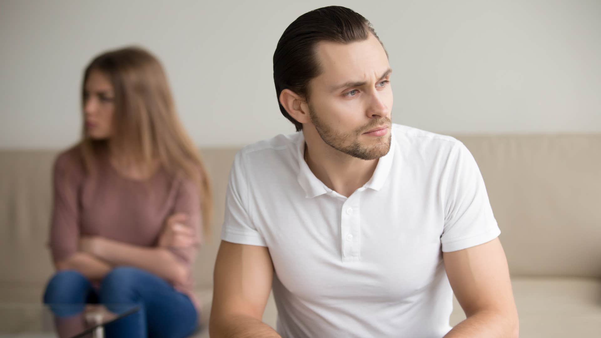 man thinking over problem sitting on couch with woman