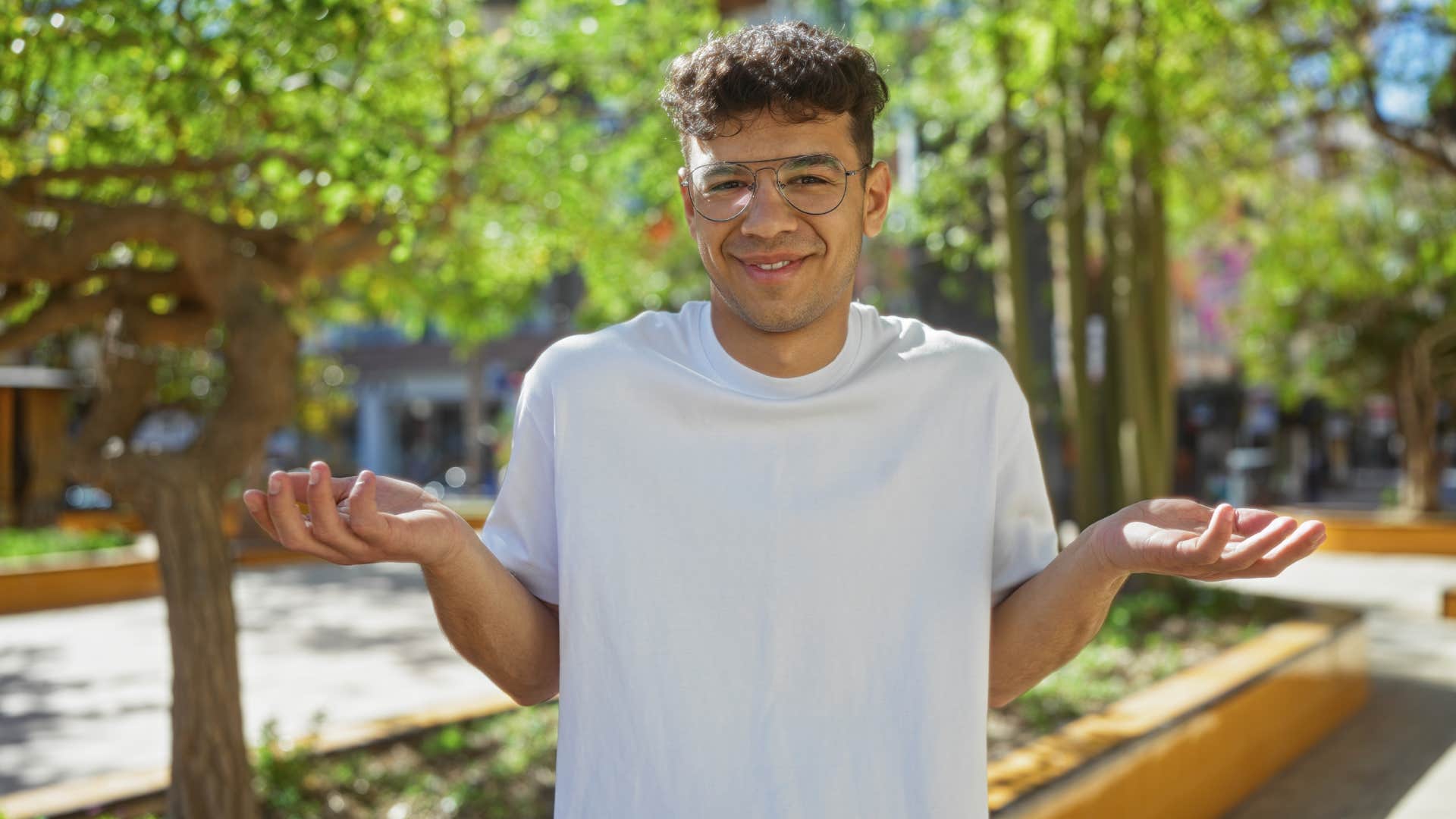 man shrugging in an urban park