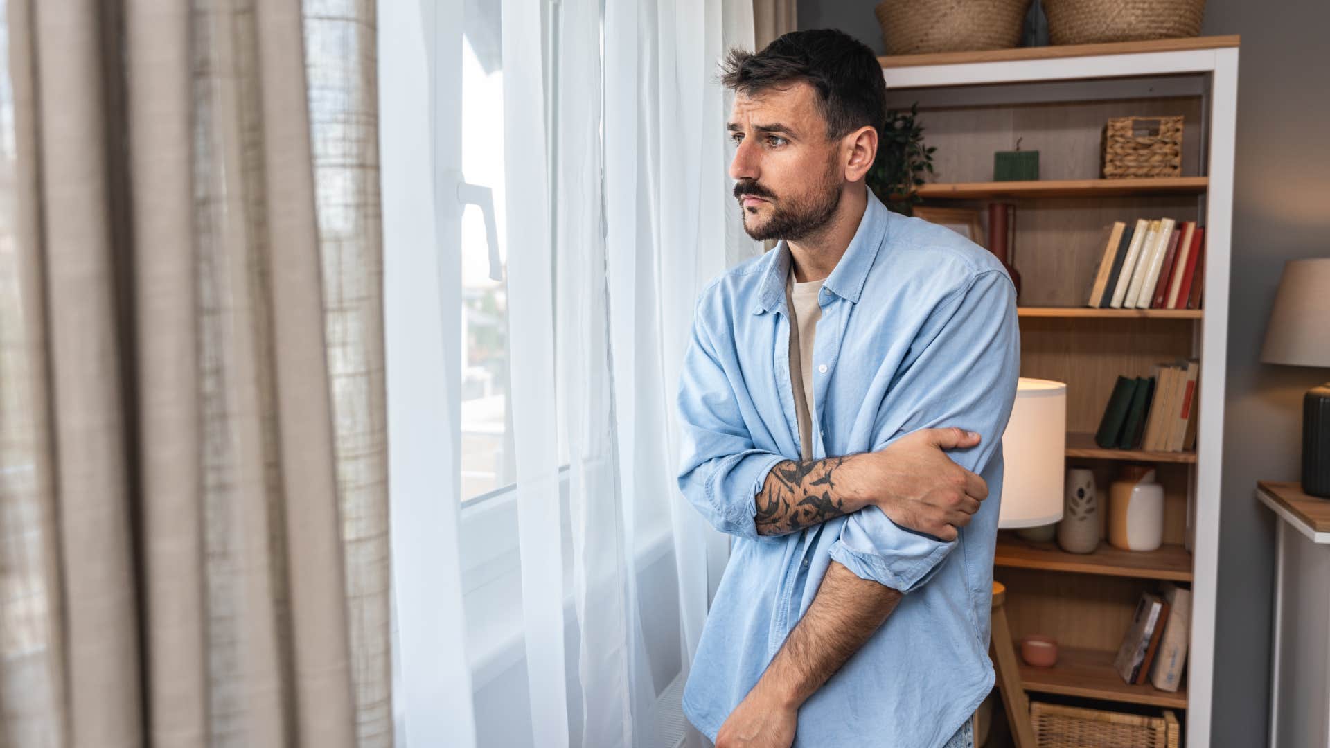 sad man standing near window