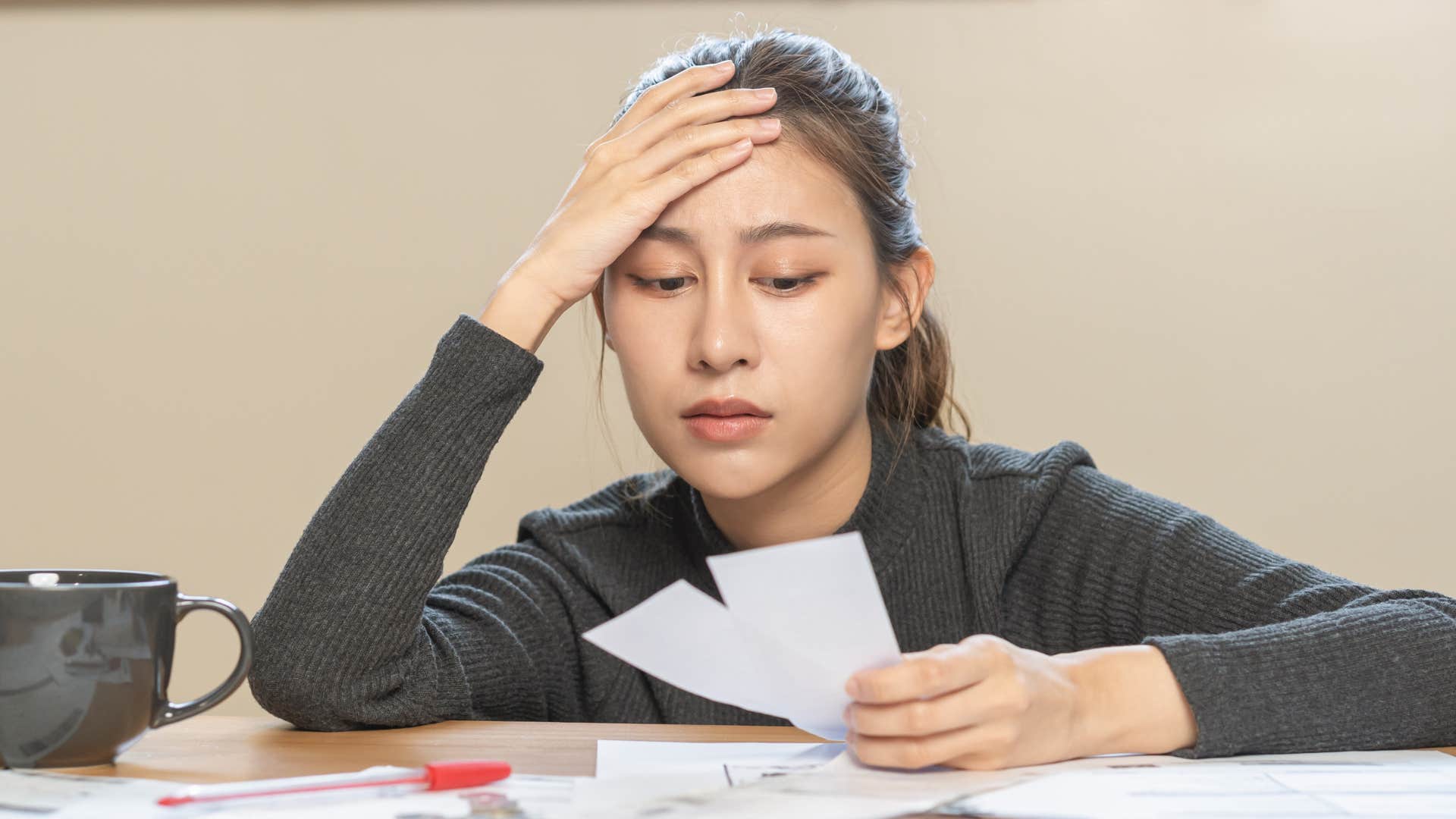 Gen Z woman holding her head looking stressed