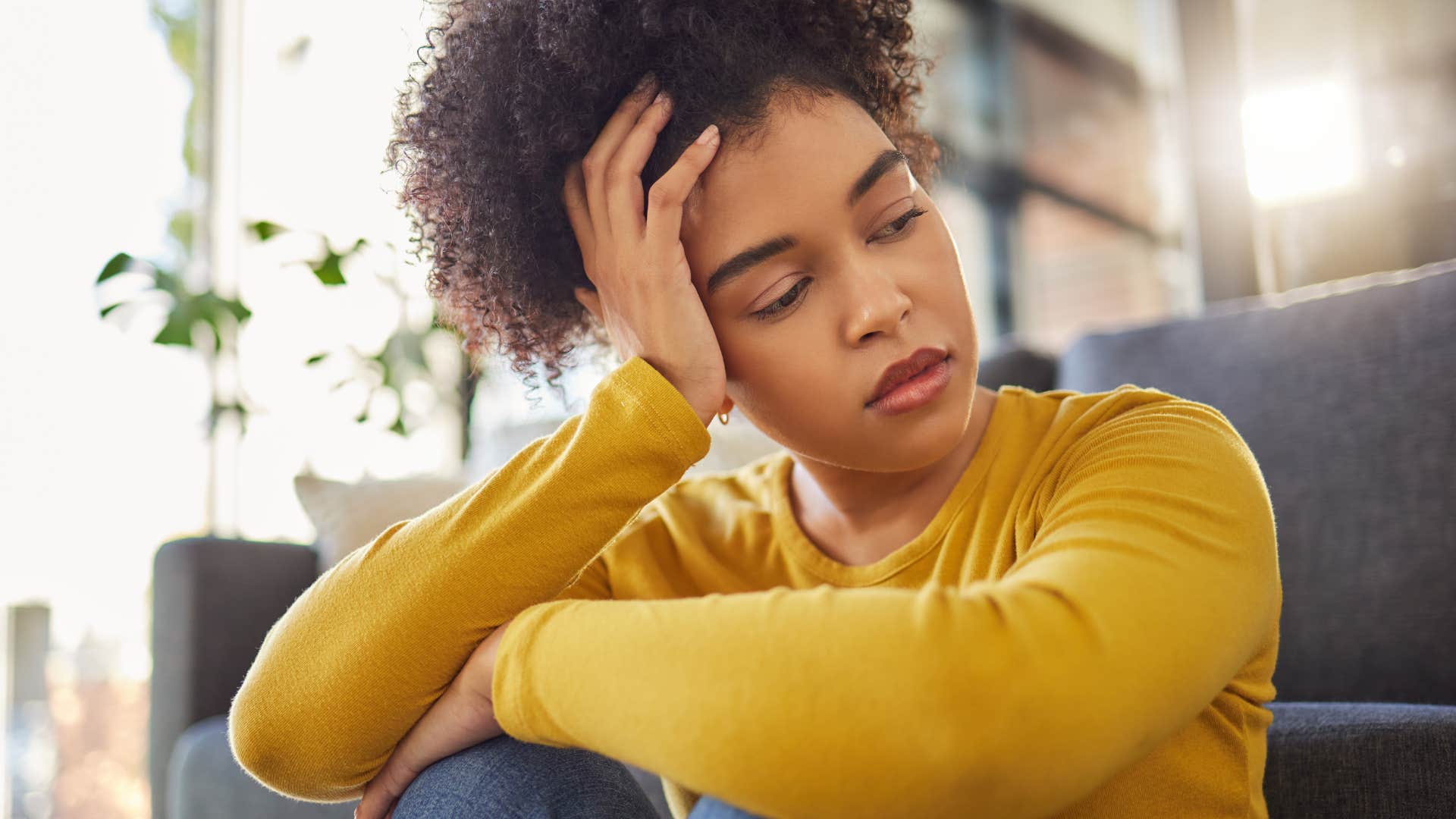 Gen Z woman holding her head and looking stressed