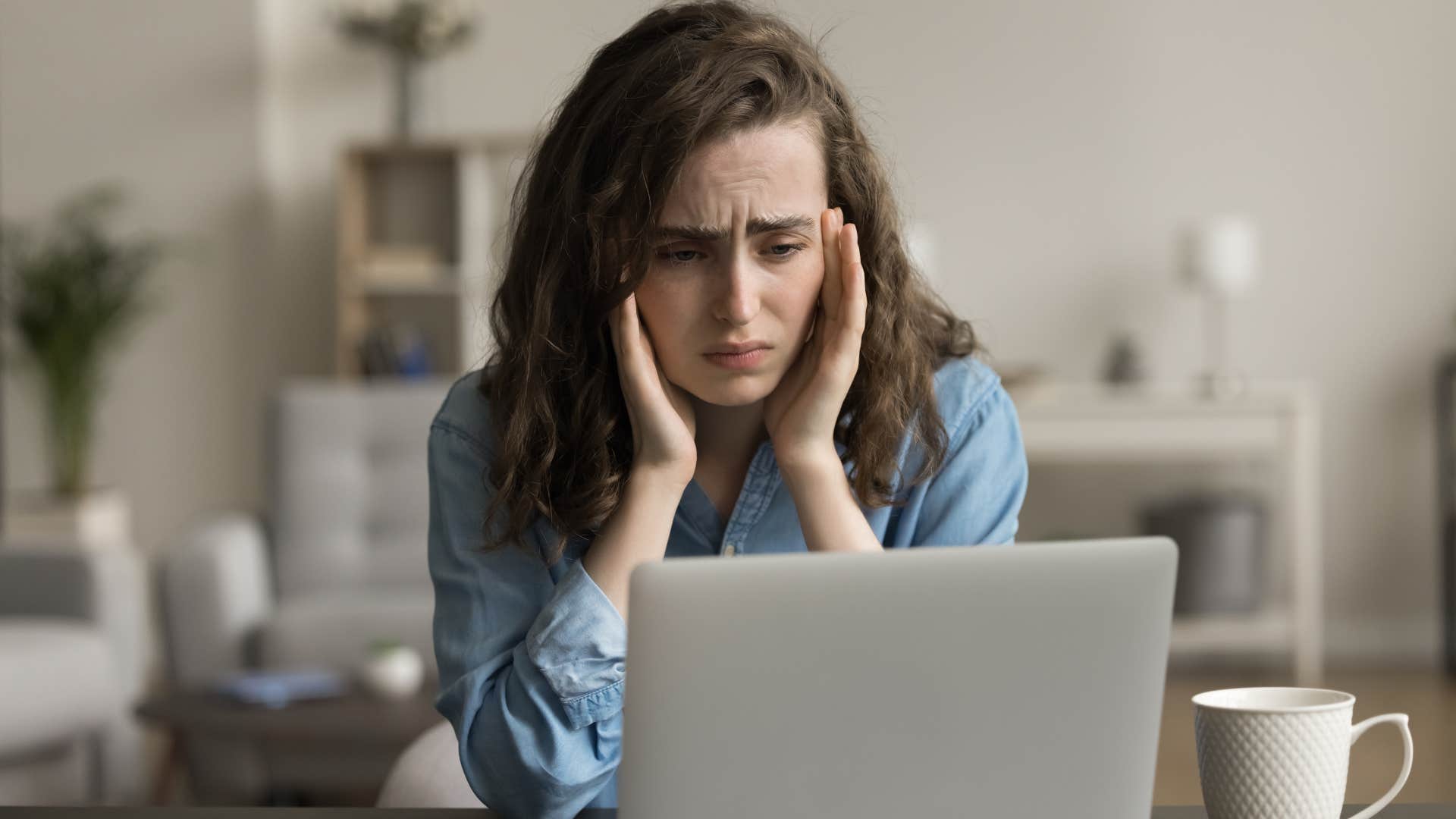 Gen Z woman looking stressed staring at her laptop