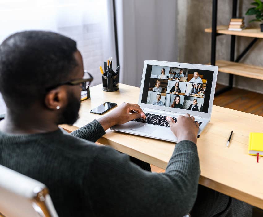 Man talking online with employees via video connection