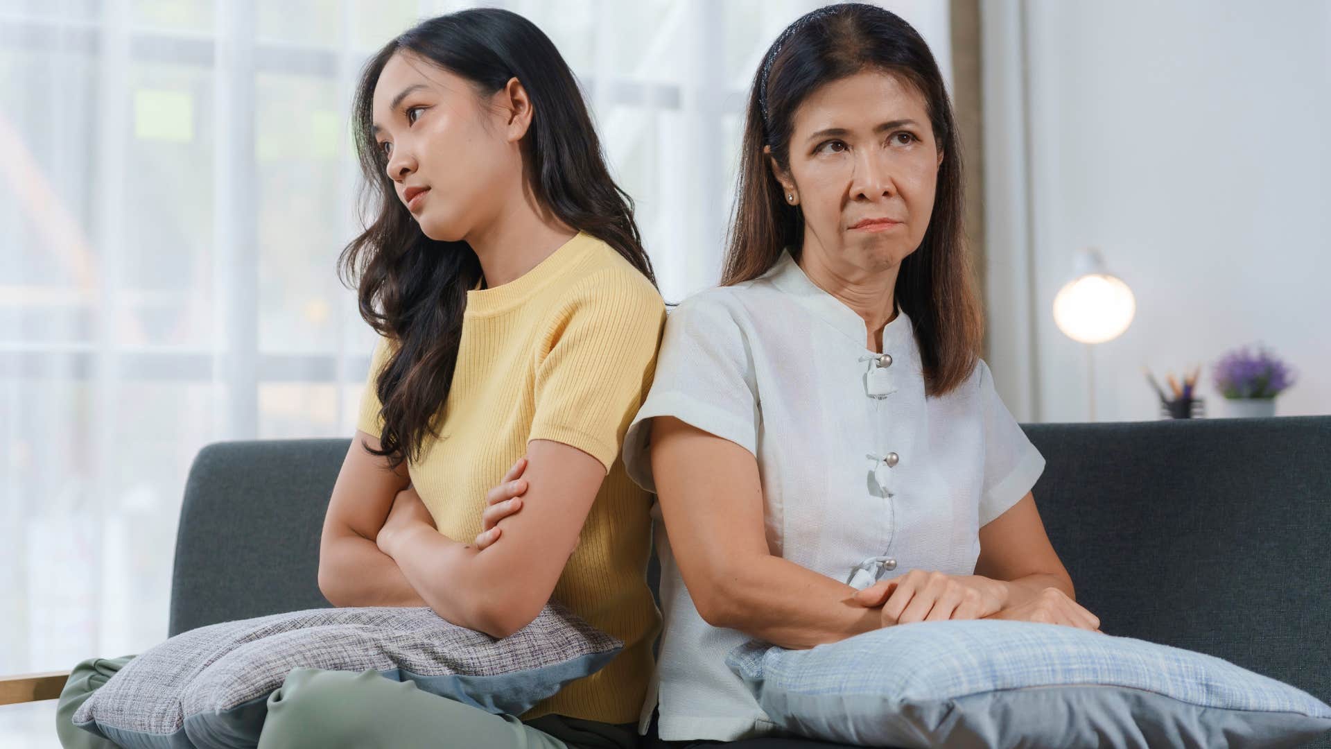 Adult daughter and mother facing away from each other