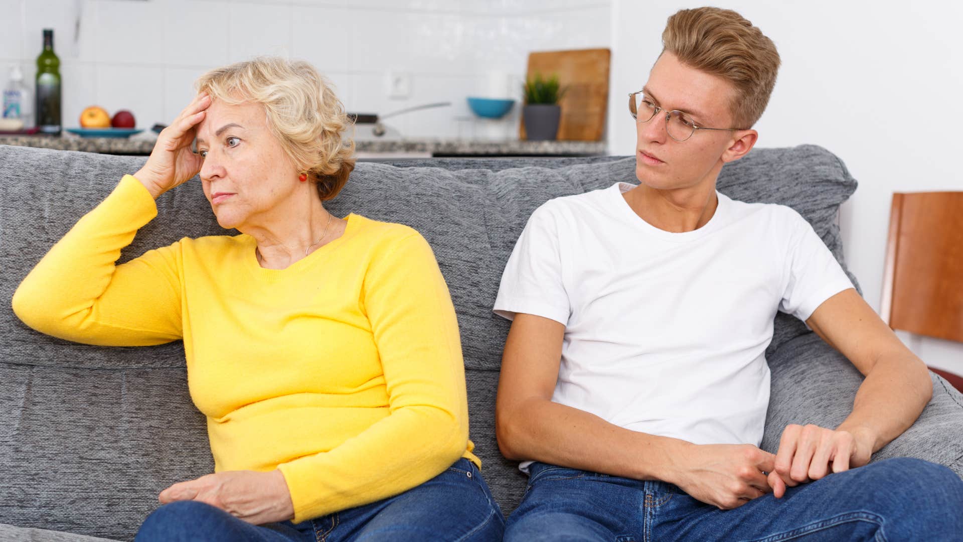 Woman looking away from her upset adult son