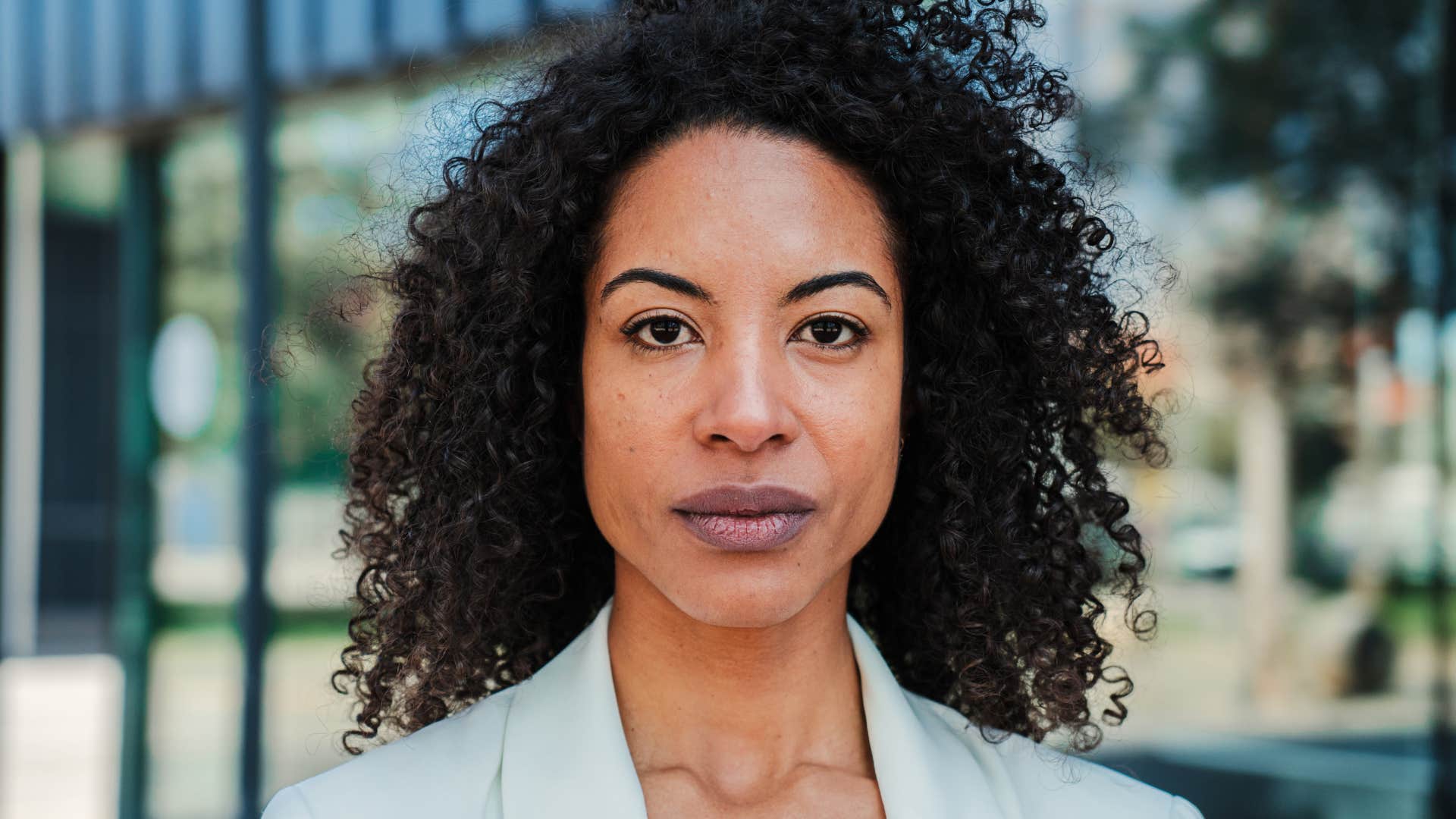 Serious businesswoman looking pensive at camera with proud attitude 