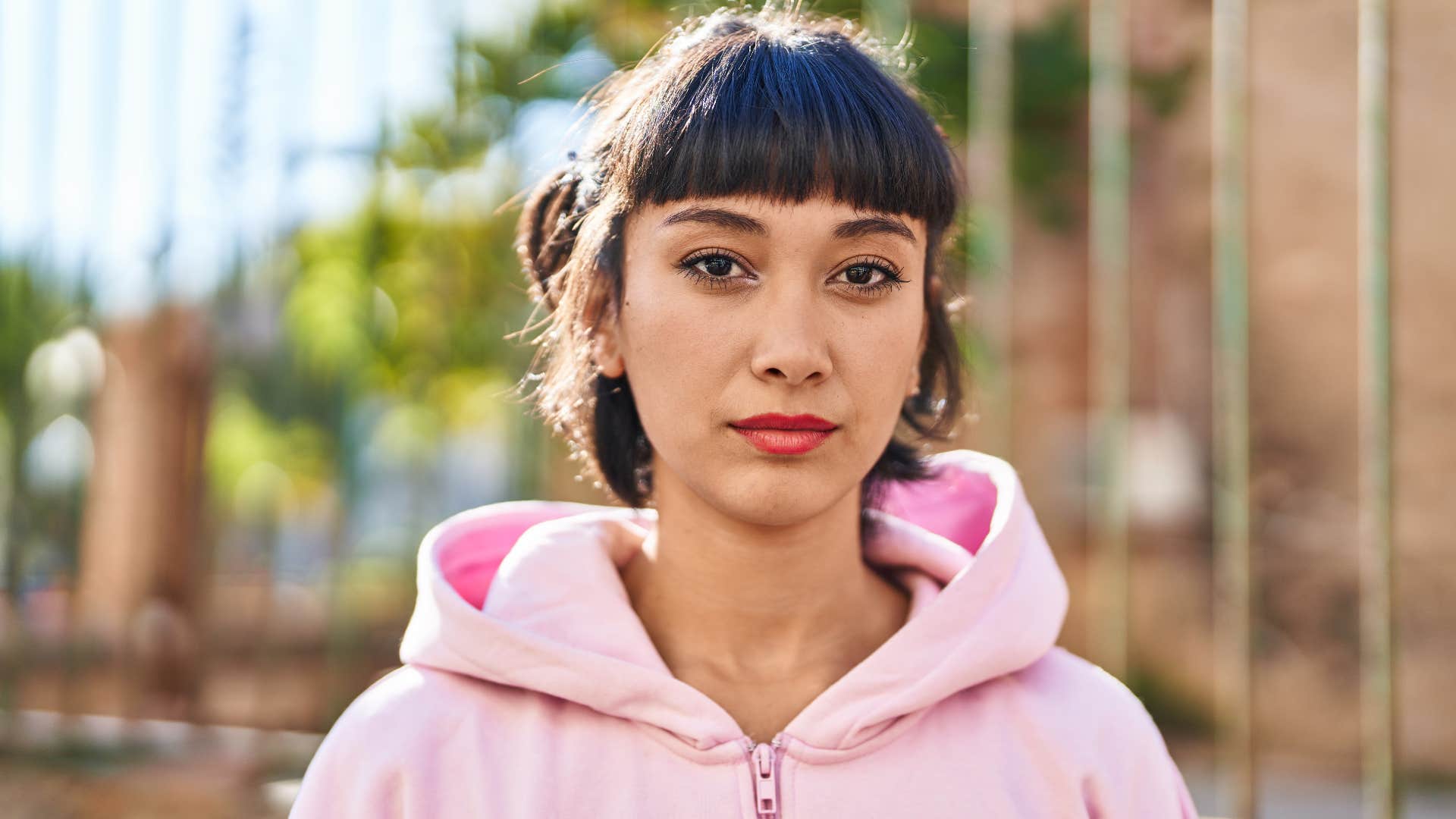 Young woman standing with relaxed expression at street