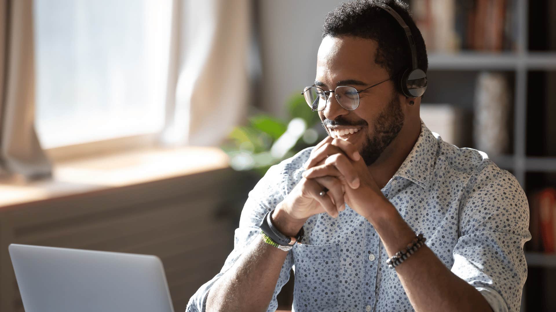 man smiling while working on laptop