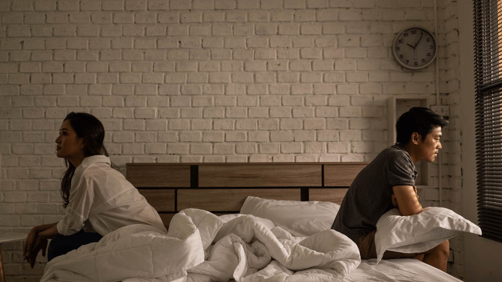 couple facing away from each other in bed