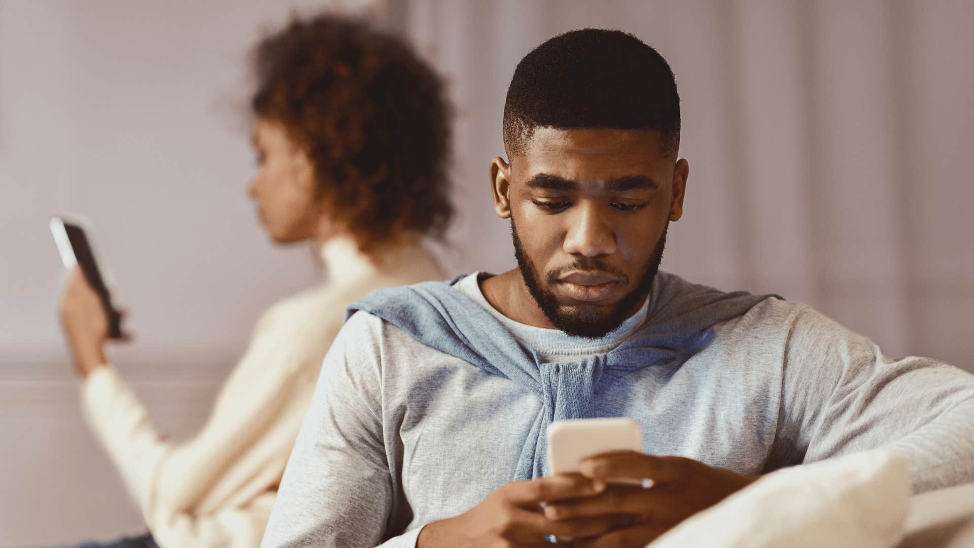 couple both on cellphones ignoring each other