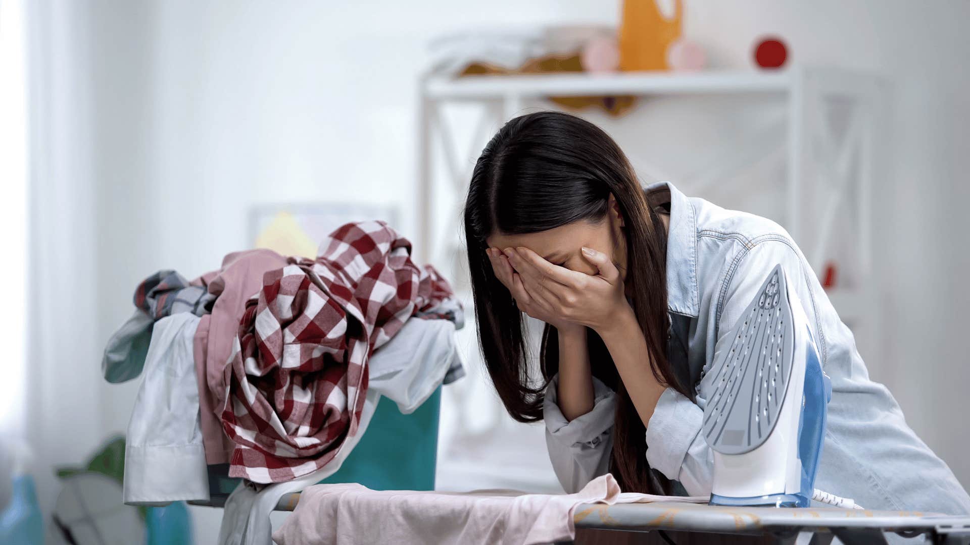 Stressed out woman with clothes and ironing board