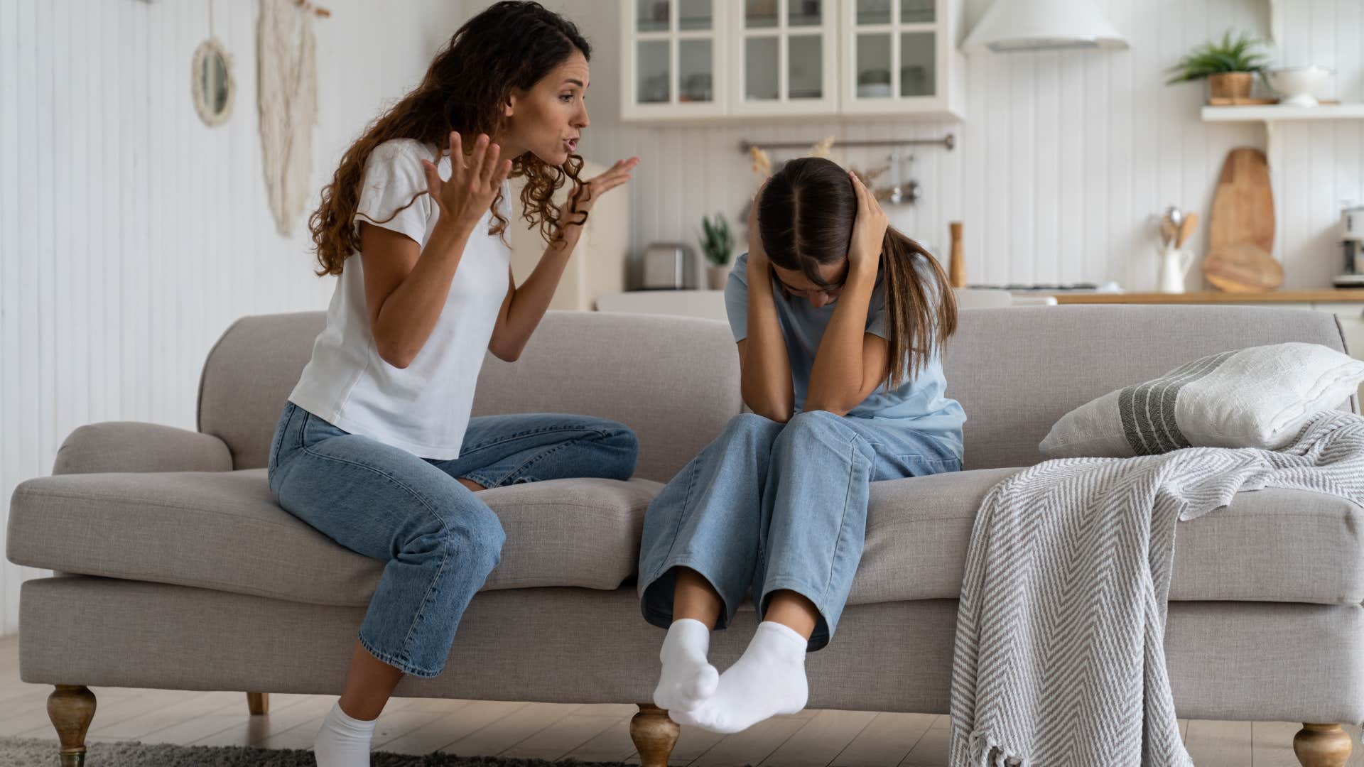 mom yelling at her daughter sitting on the couch