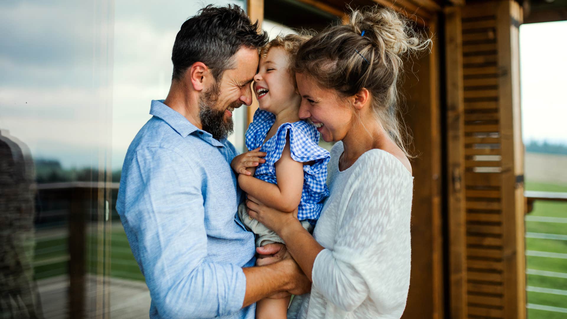 happy couple hugging their daughter