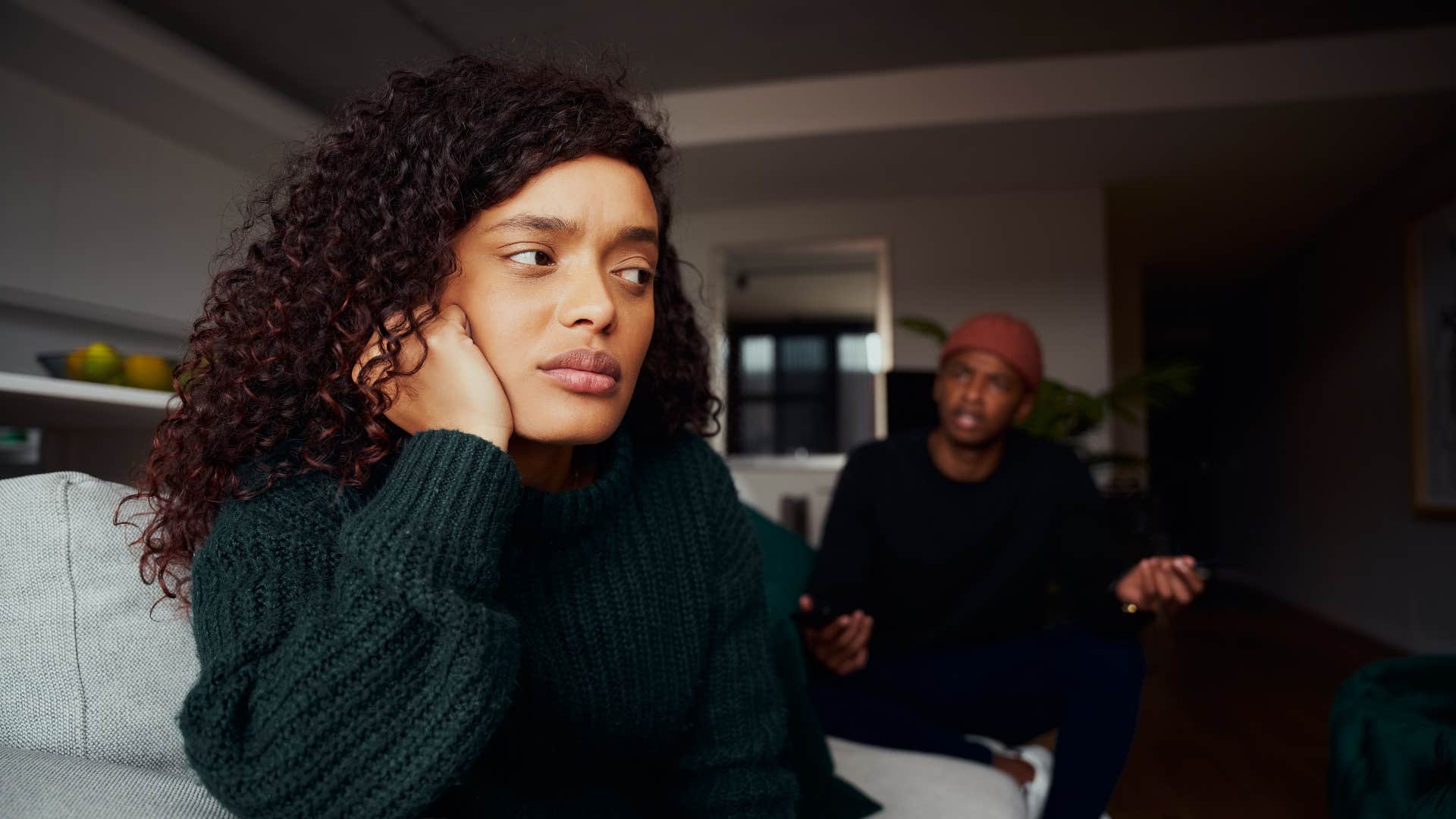 couple arguing while sitting on couch