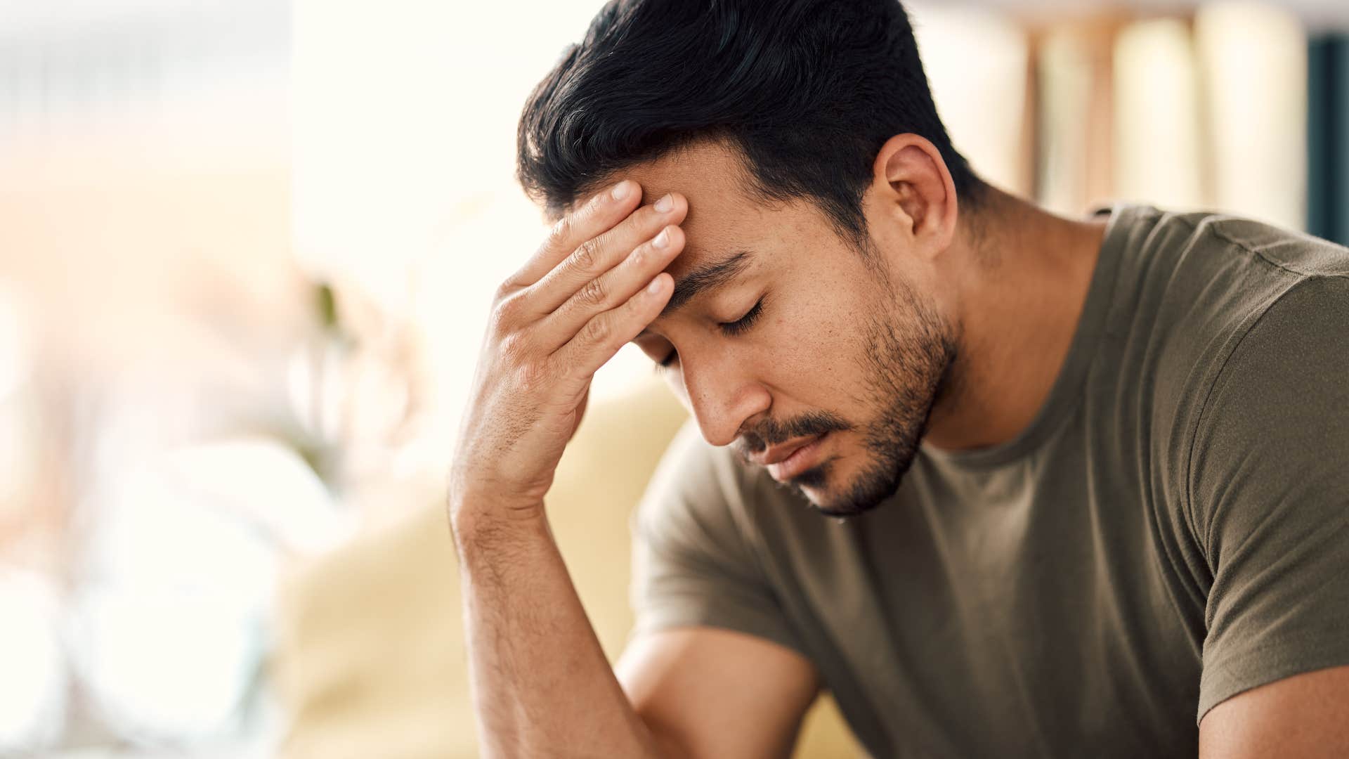 Man holding his head looking upset.