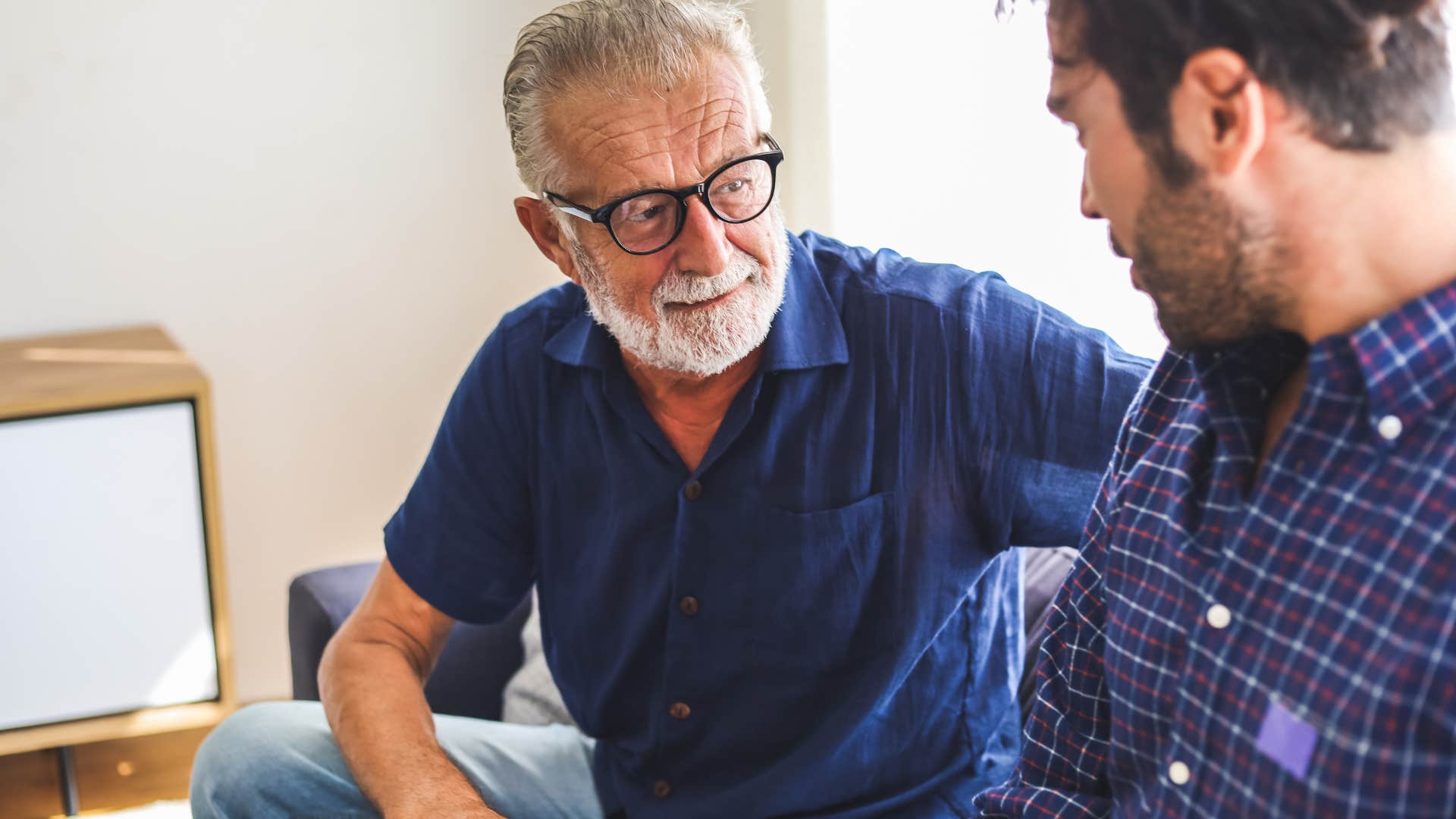 Man talking to his adult son at home.