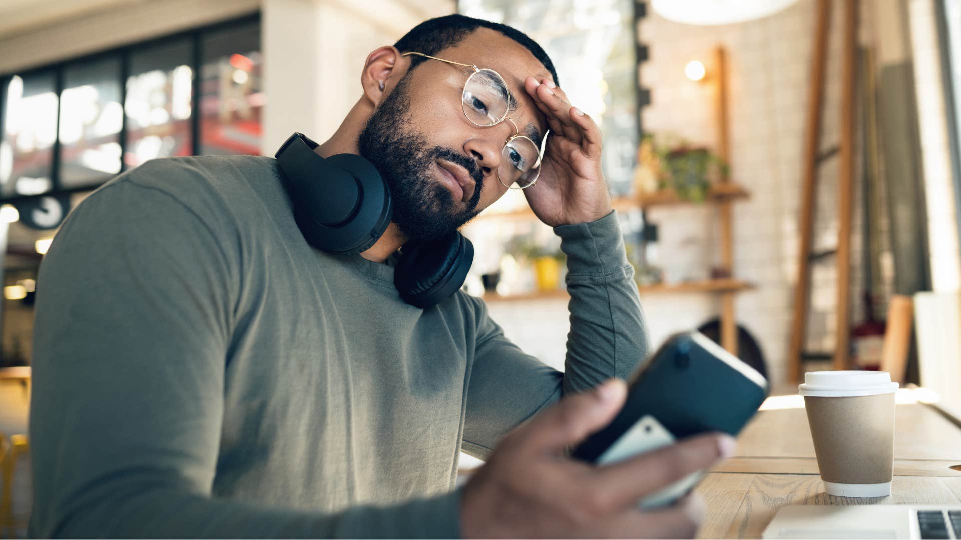 Man looking stressed staring at his phone.