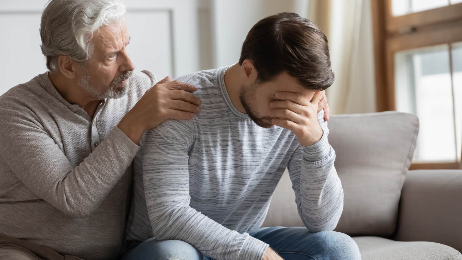 Dad comforting his upset adult son.