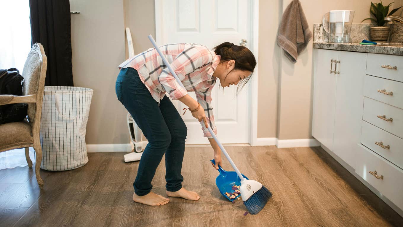 Woman brooming the floor