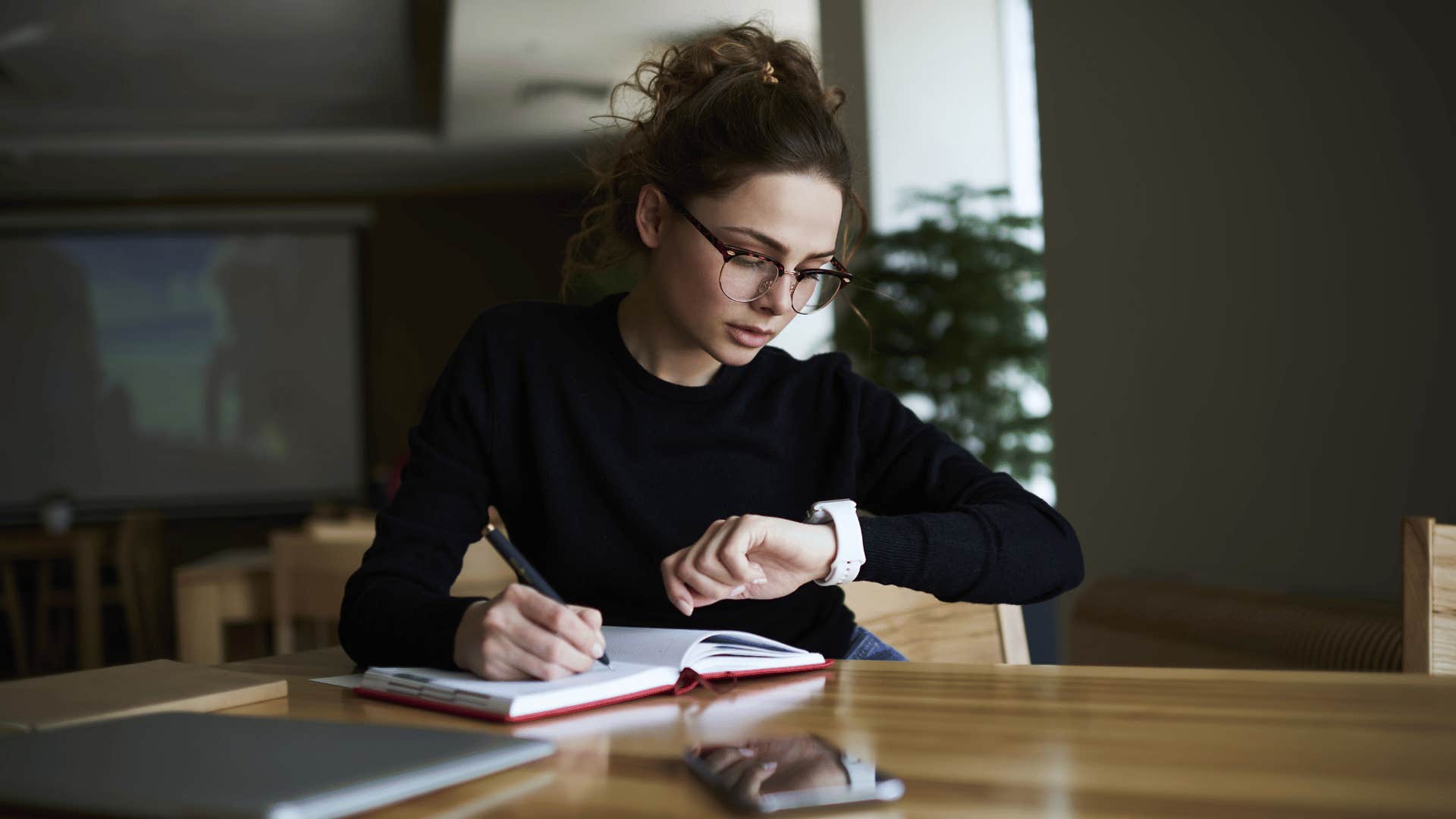 woman checking time while working