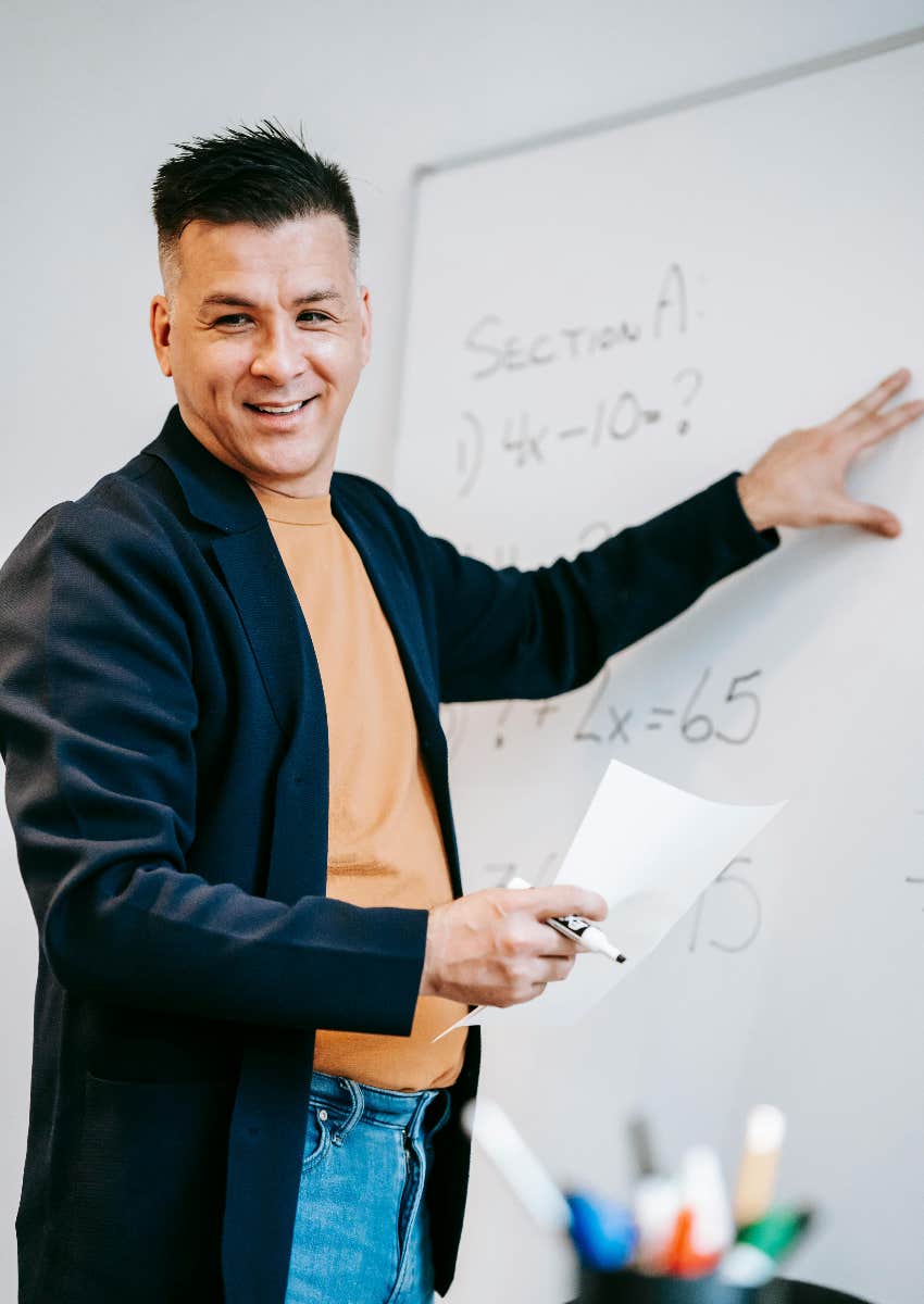 male teacher pointing to whiteboard