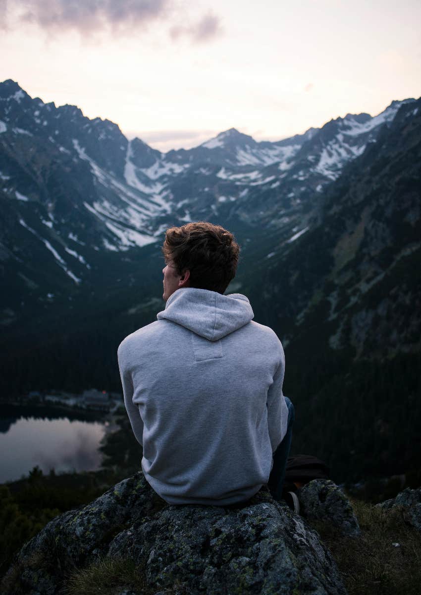 man sitting alone on a mountain