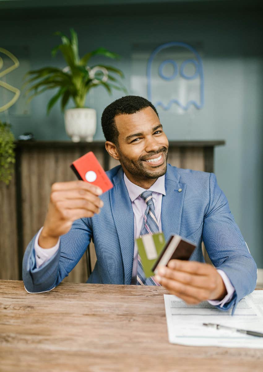 successful businessman holding credit cards