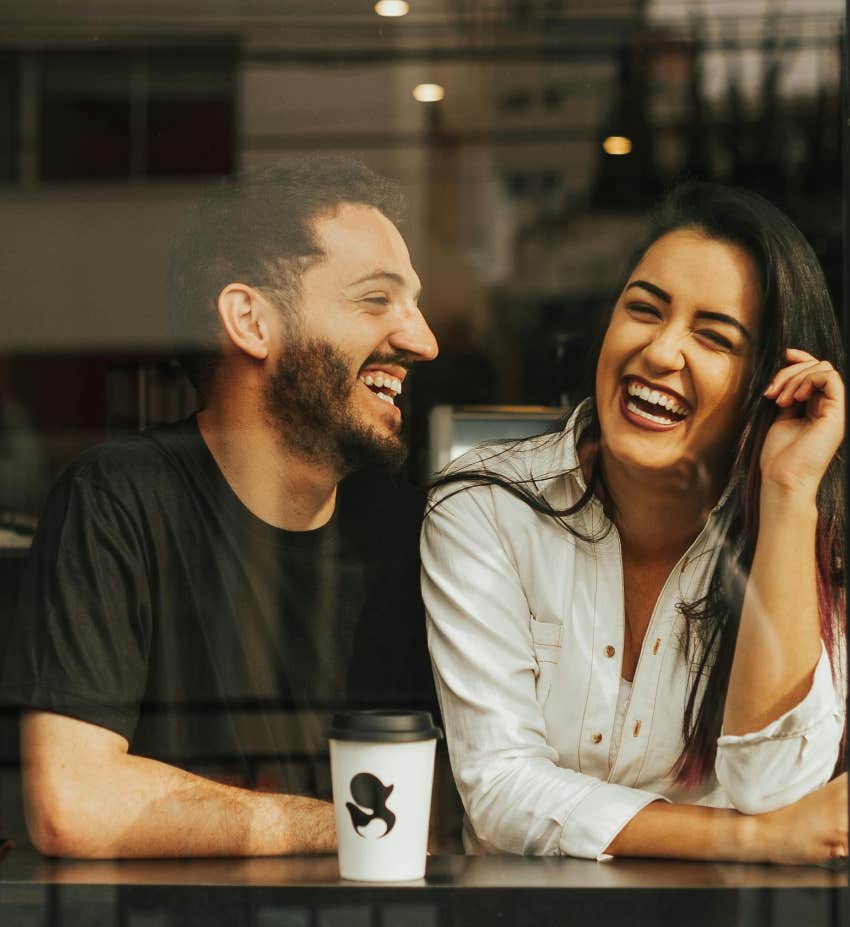 man and woman sitting together laughing